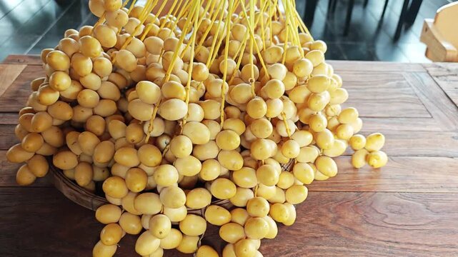 High Angle View of Fresh Yellow Date Palm Cluster on Wooden. Table