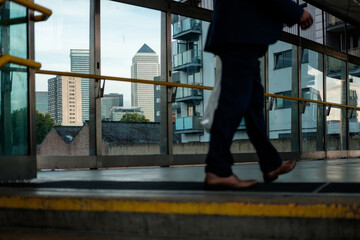 Obraz premium Business person walking through canary wharf with skyline