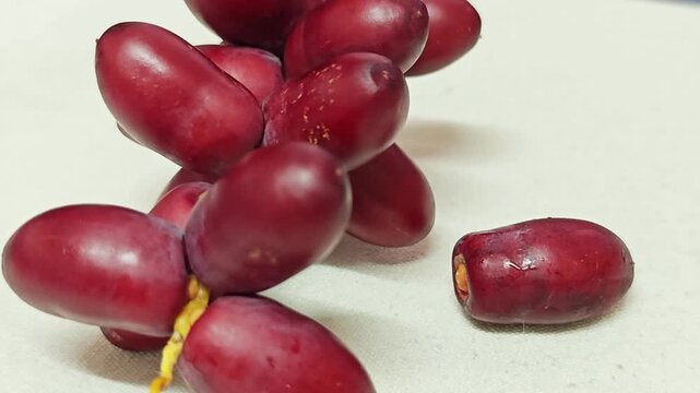 Fresh Red Dates Cluster with Single Fruit on Cream Background.