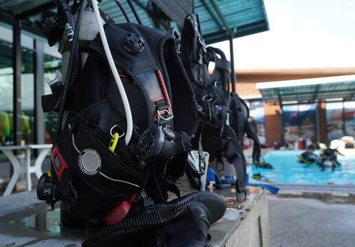 Scuba diving equipment with oxygen tank near swimming pool