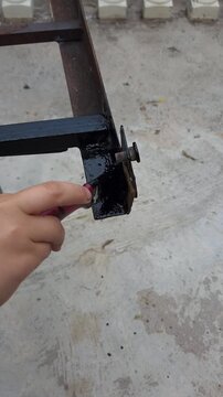 Child Hand Carefully Painting Corner of Iron Frame Structure