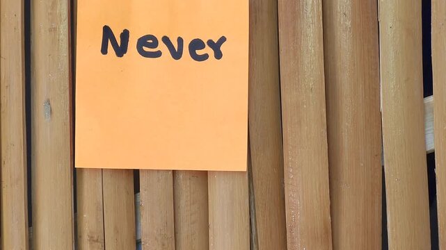 Sticky Note with Word Never Attached to Bamboo Stalks