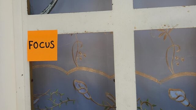 Sticky Note on Window Frame Displaying the Word Focus