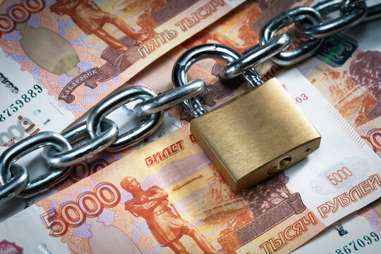 Padlock with chain on banknotes of Russian rubles. Ban, blocking Russian rubles.