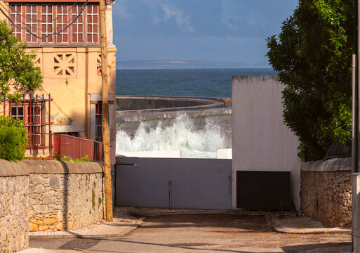 Ocean Waves Breaking Against Seawall in Cascais Residential Waterfront, Portugal