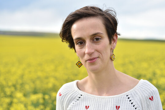 Close-up portrait of a brunette woman in a field