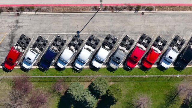 Top down aerial view of new row of Semi trucks at parking lot