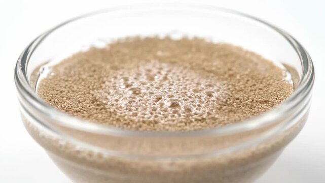 Close up of food grains in a glass bowl, powder dissolving process when exposed to water