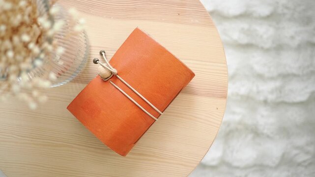 Handmade leather notebook on a wooden table in a bright room