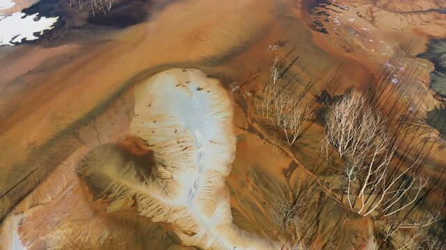 Aerial abstract surreal natural patterns above. Colorful chemical mining leach residues in decanting pond by drone