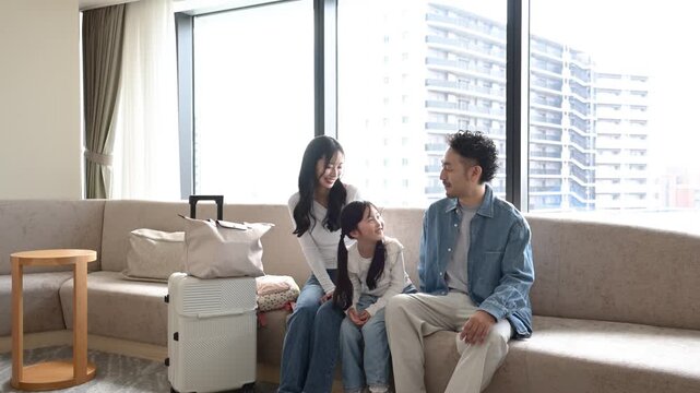 旅行先のラウンジで会話を楽しむ30代日本人夫婦と6歳の子ども