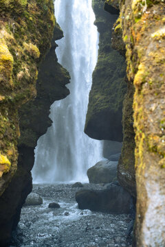 Vertical photo of the entrance to the Gljufrabui waterfall inside a canyon near Seljalandsfoss on a March day