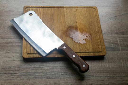 Knife and chopping board on a wooden background. Top view.