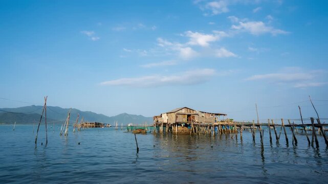 Timelapse of a traditional wooden fishing stilt house over calm sea water during late afternoon in Vietnam.