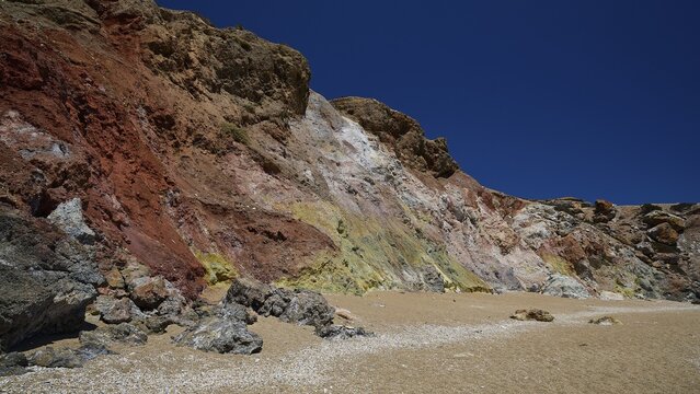 Colored rocks rise against a clear blue sky on a beach, Paliochori beach, Paliochori, volcanic rock, copper, nickel, mineral salts, volcanic island, Milos, Cyclades, Greek islands, Greece