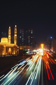 Night long exposure Sharjah Four Khalifas intersection.UAE futuristic architecture. Illuminated Masjid Abu Bakr Al Siddiq, Umar bin Al Khattab, Uthman bin Affan, Ali bin Abi Talib mosque light trails