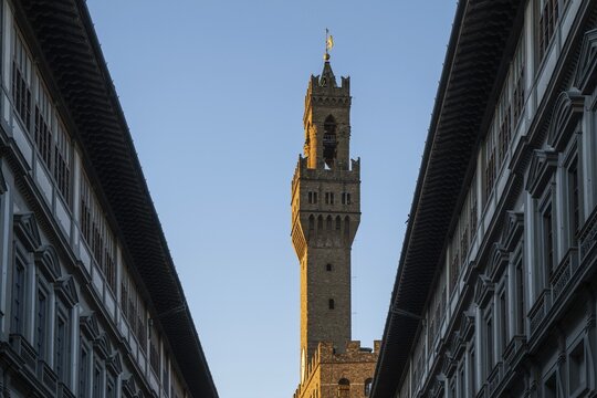 Uffizi wing, Italian Galleria degli Uffizi, art museum, behind the tower of the Palazzo Vecchio in the evening light, old town, Florence, Tuscany, Italy