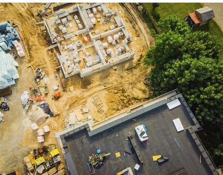 Aerial close up New Constructions real estate Development Site. Urban Construction Site, Aerial View. Rooftops and building construction site with worker laying material.Siauliai. Lithuania