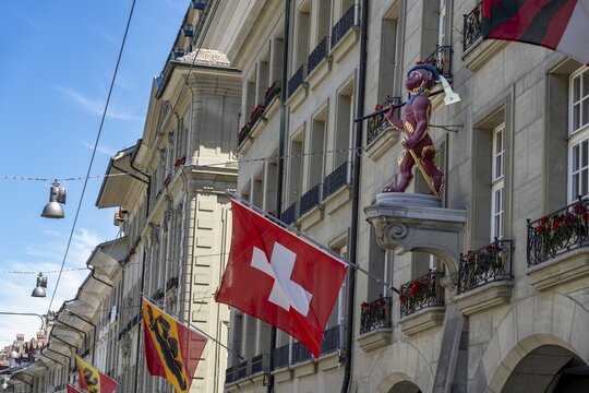 House sign at the guild house of the guild society to the monkey, monkey figure with Swiss national flag on a house fa&ccedil;ade in the city center, Kramgasse, Bern, Canton of Bern, Switzerland