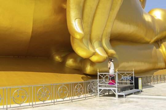 Thailand's largest Buddha statue (Luang Pho Yai), Thai woman, Wai gesture (traditional gesture of respect, greeting or thanks), Wat Muang, Ang Thong, Amphoe Wiset Chai Chan province, Thailand