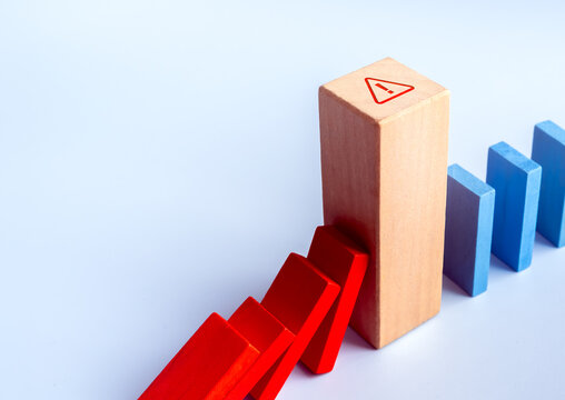 Wooden blocks illustrating business risk management and domino effect prevention. Financial risk, crisis management, strategic planning, business continuity, and operational resilience.