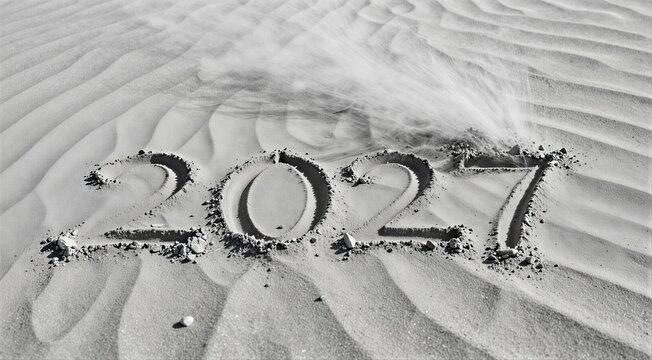 2027 numbers written in sand with wind forming ripples on beach surface