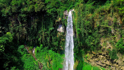 Aerial view of grojokan sewu Waterfall in Indonesia streaming down, cascades down steep, verdant cliffside, through dense jungle. Ideal for travel © faiz
