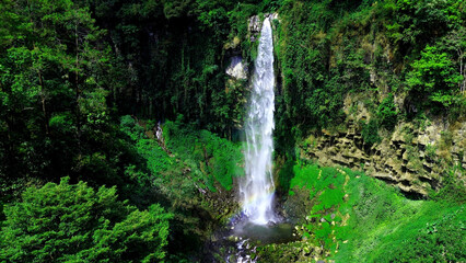 Aerial view of grojokan sewu Waterfall in Indonesia streaming down, cascades down steep, verdant cliffside, through dense jungle. Ideal for travel © faiz