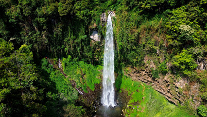 Aerial view of grojokan sewu Waterfall in Indonesia streaming down, cascades down steep, verdant cliffside, through dense jungle. Ideal for travel © faiz