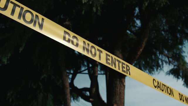 Yellow caution tape marking a restricted hazard area emphasizes safety measures and prevents access to a potentially dangerous outdoor location