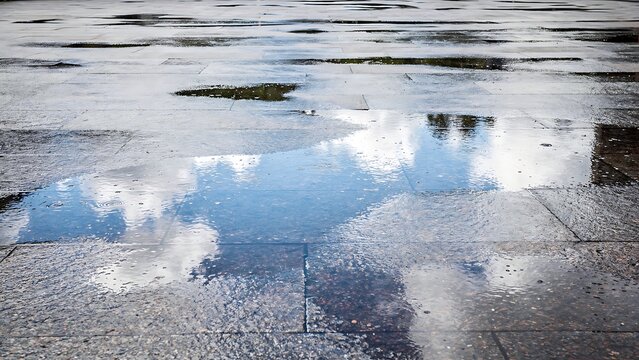 Rain Washed Stone Pavement Reflecting Blue Sky and White Clouds