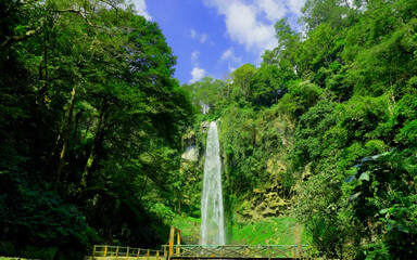 Waterfall of grojokan sewu in Indonesia streaming down, cascades down steep, verdant cliffside, through dense jungle. Ideal for travel , nature promos, and tourism features © faiz