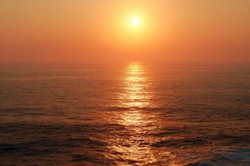 Obraz premium Golden sun dips below the horizon, casting a warm, fiery glow across the ocean waves