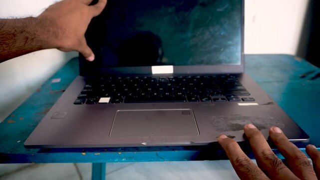 A person opening a laptop computer on a desk, capturing the start of a workday, office routine, and digital technology use for modern remote business tasks.