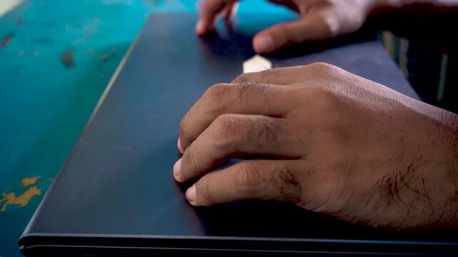 An anxious person closing a laptop computer and showing a restless movement with hands on a desk, capturing workplace stress, frustration, and burnout emotions.