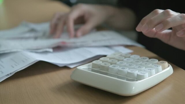 Close up of a calculator, credit card, invoices and receipts on a desk for budgeting, bill payment, debt calculation and home finance.