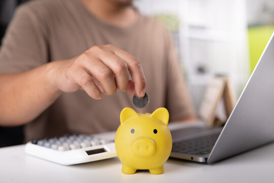 Man hand putting coin into piggy jar. Concept of saving money for buying new car, auto loan, investment, and insurance.