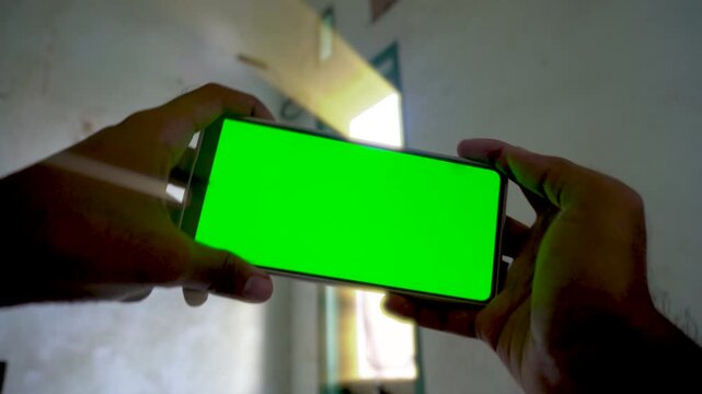 Dynamic zoom in and zoom out transition effect on a smartphone with a green screen display, capturing mobile gaming, application use, and digital technology concepts.