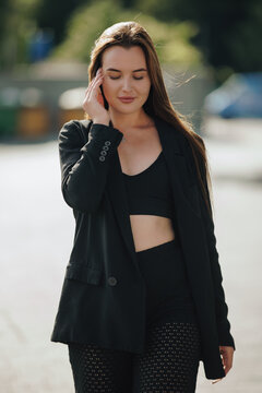 Sensual woman with closed eyes touching hair in natural afternoon backlight