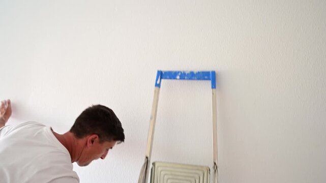 Professional painter renovating a room painting a wall
