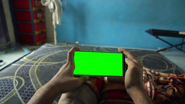 Dynamic zoom out and zoom in transition effect on a horizontal smartphone with a green screen display, capturing mobile gaming, application use, and digital technology concepts.