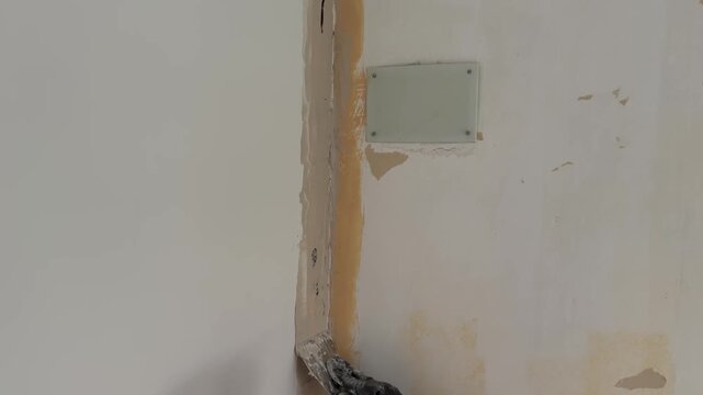 Worker plastering a wall with a spatula