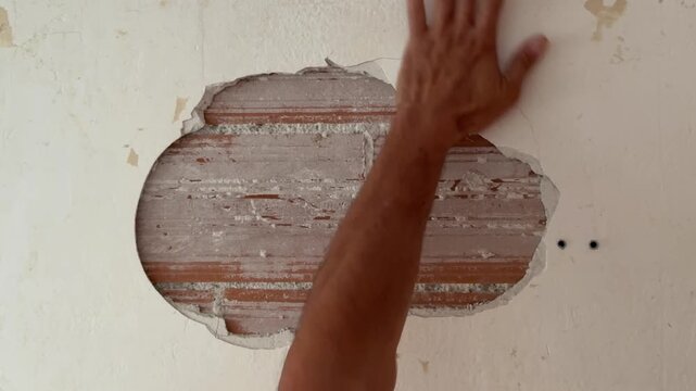 Handyman repairing a large hole on an interior wall