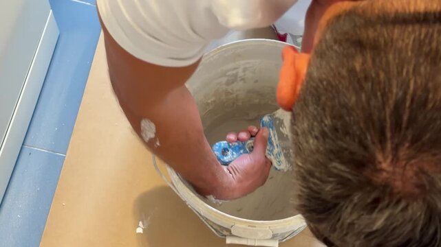 Handyman mixing plaster putty in a bucket