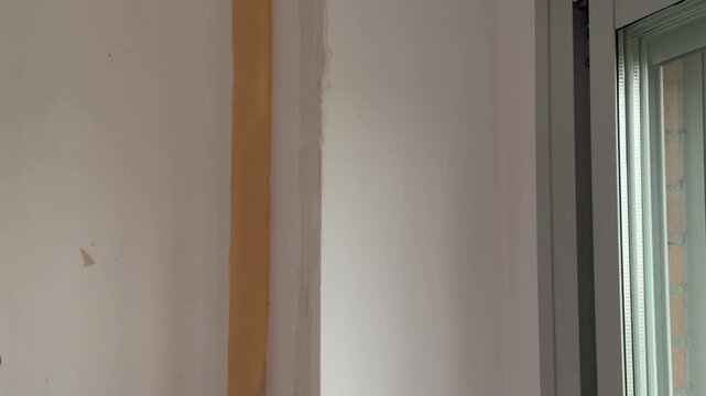 Plasterer applying putty compound on a wall