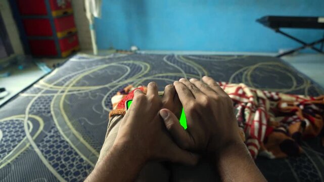A person secretly watching a smartphone with a green screen display in a room, capturing covert mobile phone use, hidden browsing, and stealth behavior concepts.