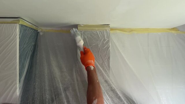 Professional painter painting a ceiling with white paint