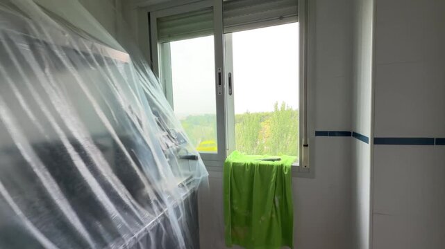 First person view walking through a kitchen under renovation towards the window