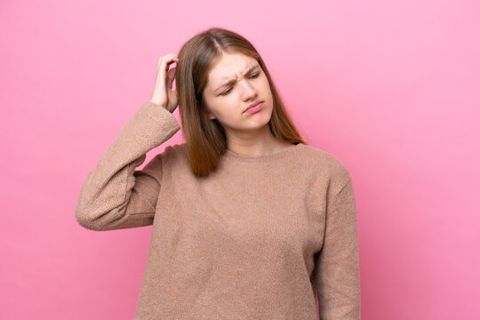 Teenager Russian girl isolated on pink background having doubts while scratching head
