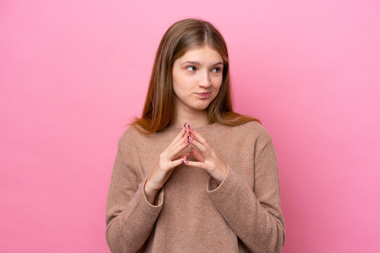 Teenager Russian girl isolated on pink background scheming something